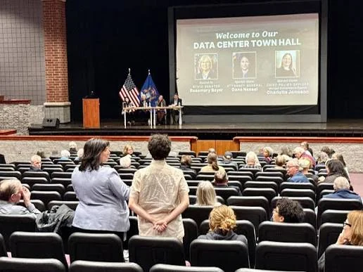 Residents at a data center town hall in a school auditorium